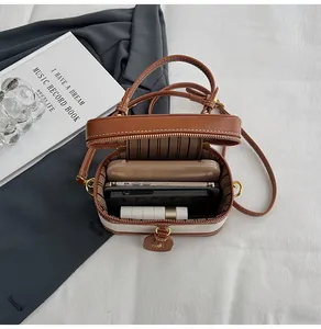 Vista interna della borsa a scatola a contrasto con spazio per due telefoni e rossetto