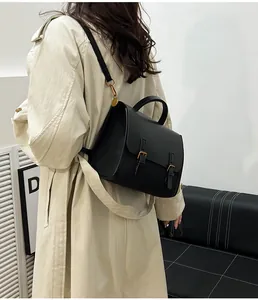 Side view of black vintage satchel bag with gold buckles and leather top handle