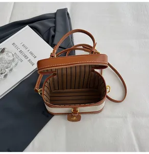 Dettaglio dell'interno della borsa vintage con fodera a righe e chiusura a zip