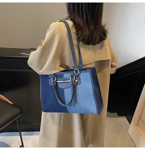 Detalle del bolso tote de mezclilla bicolor con costuras de contraste y gran capacidad