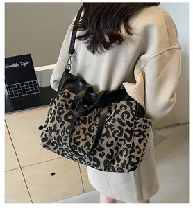 Détail du sac cabas léopard avec anses en cuir noir et bandoulière réglable chic