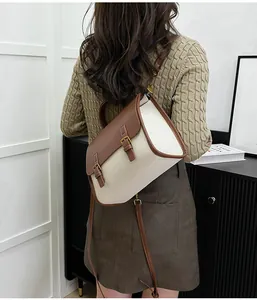Detail of a brown and cream messenger bag shown on a model for size and fit