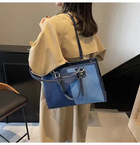 Vista de detalle de un bolso tote de mezclilla patchwork con cremalleras decorativas