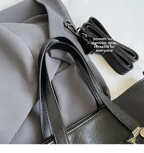 Détail du sac cabas en cuir noir avec sa longue bandoulière réglable et lisse