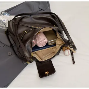 Detalle de un bolso tote marrón grande con compartimentos internos y cuero sintético PU
