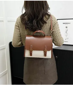 Detailed view of vintage two-tone messenger bag with brown leather flap and beige canvas