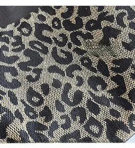 Gros plan sur la texture du tissu tissé à motif léopard avec fils noirs et beiges