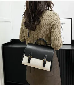Detailed back view of vintage-style leather and canvas messenger bag with gold hardware