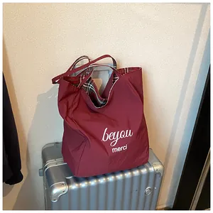 Close-up of burgundy leopard print tote bag interior featuring classic red and black plaid lining