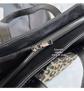 Gros plan détaillé de la fermeture éclair lisse sur un sac cabas noir avec tissu jacquard