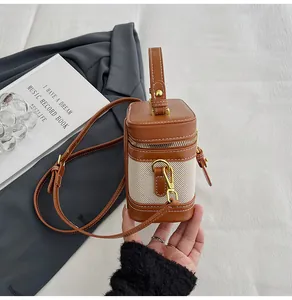 Dettaglio borsa a scatola vintage con finiture in pelle marrone e tessuto beige chiaro