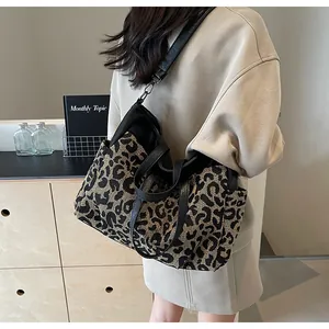 Vue détaillée d'un sac cabas imprimé léopard avec des anses en cuir noir sur un mannequin