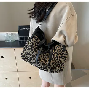 Détail du sac cabas imprimé léopard avec bandoulières en cuir noir en situation réelle