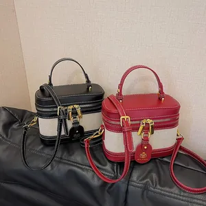 Dettaglio delle borse a tracolla vintage in nero e rosso con finiture in metallo oro