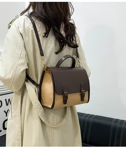 Detail of vintage patchwork messenger bag showing leather flap and metal hooks