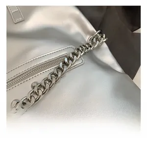 Close-up of chunky metal chain strap and silver synthetic leather bag texture