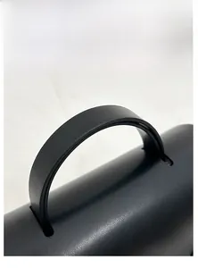 Close-up of the durable matte leather handle with fine stitching on a vintage satchel