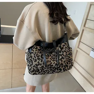 Détail du grand sac cabas avec motif léopard et bandoulière en cuir noir