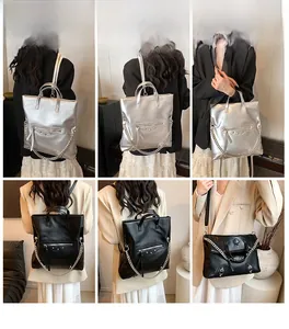 Model display of silver and black leather backpacks with rivets and chain details