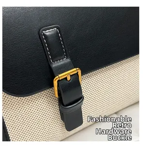 Detail of vintage gold buckle on a black leather and white canvas patchwork handbag
