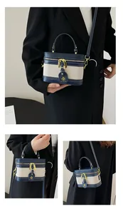 Dettaglio della mini borsa box in tela e pelle a contrasto con finiture oro