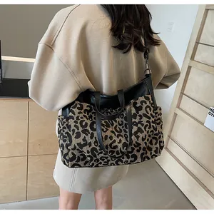Vue arrière d'un mannequin portant un grand sac cabas imprimé léopard avec des anses noires