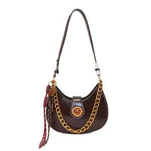 Dark brown crescent shoulder bag in glossy faux leather with gold chain and strap
