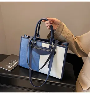 Detalle del bolso tote en denim y lona tricolor con cremallera plateada