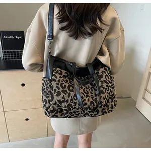 Sac fourre-tout léopard avec poignées noires et bandoulière portées à l'épaule