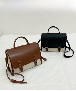 Detailed look at the canvas and leather paneling of two-tone vintage messenger bags
