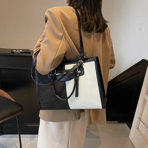 Elegante bolso tote de lona en blanco y negro con flecos y correa al hombro