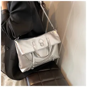 Detail of silver metallic synthetic leather backpack with chain and ring clasp detail