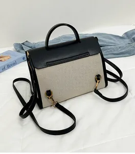 Detail view of vintage contrast color messenger bag with leather trim and gold metal hardware