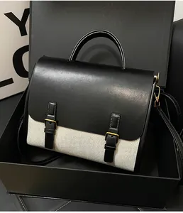 Detail shot of the canvas and black leather vintage messenger bag in a premium gift box