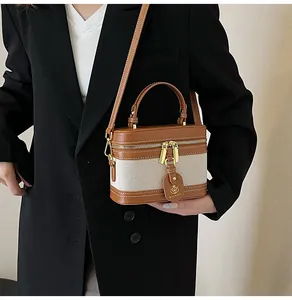 Dettaglio della mini borsa a scatola con tela bicolore e finiture in metallo oro