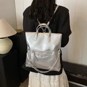 Metallic silver fashion backpack for women with chains and vintage rivets in a trendy style