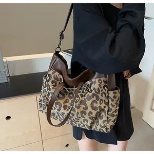Détail du sac cabas léopard montrant la texture tissée et la bandoulière en cuir brun
