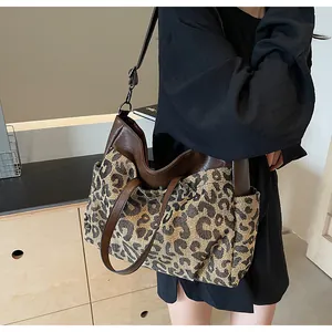 Détail du sac cabas léopard avec poche latérale en toile et bandoulières en cuir