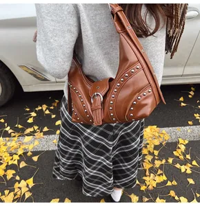 Vue détaillée du sac sous le bras marron Y2K avec rivets argentés et boucle sur la rue