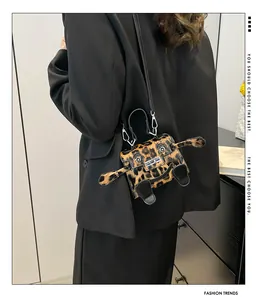 Detail of leopard print mini monster bag with 3D eyes and silver lock on black blazer