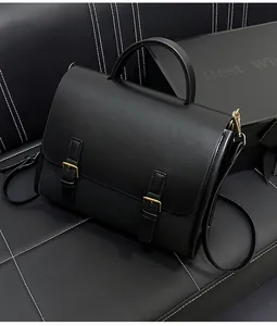 Detail of vintage black messenger bag with leather texture and classic metal buckles