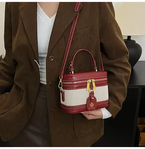 Dettaglio della borsa a scatola retrò in pelle bordeaux e tela beige con cuciture