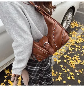 Détail du sac sous le bras en cuir marron foncé avec rivets argentés et garnitures
