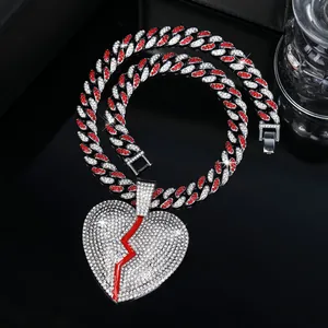Macro detail of iced-out Cuban link chain with a broken heart pendant featuring red accents