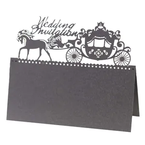 Macro shot of laser-cut black royal carriage wedding place card with foldable design