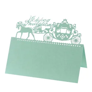 Macro detail of laser-cut mint green wedding place card with ornate royal carriage design