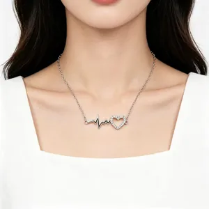 Detail shot of a S925 sterling silver heartbeat and pavé heart necklace on model