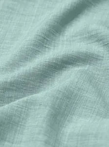 Detailed macro view of mint green breathable linen fabric texture and weave pattern