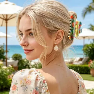 Island style hair claw clip with floral print and seashell pearl earrings on beach