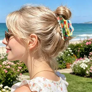 Colorful marble textured acetate hair claw clip worn on a bun at the beach